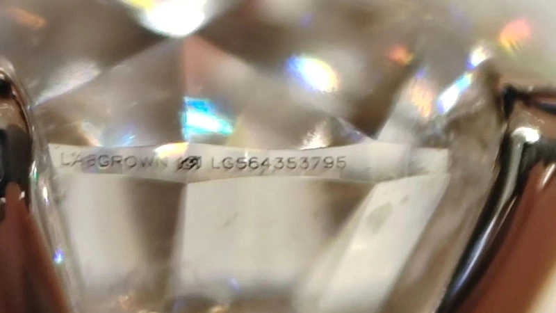 IGI certified girdle inscription of lab-grown diamond under a magnifying glass